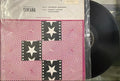 Vinyl record with a cover featuring star and spiral pattern on a reflective surface.
