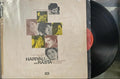 Vinyl record with a cover featuring a collage of faces on a beige background.
