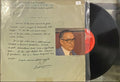 Record with a cover featuring text and a portrait, held by a stand.