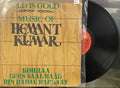 Vinyl record with a wooden cover featuring text, on a white surface.