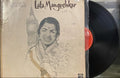 Vinyl record with a cover featuring a stylized illustration of a woman and architectural elements, with 'Lata Mangeshkar' text.
