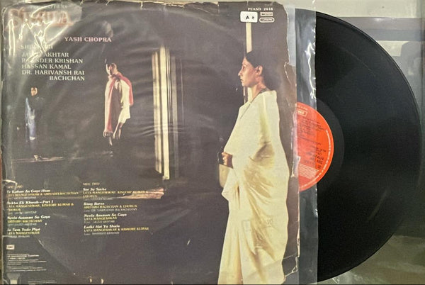 Vinyl record with cover featuring a person in a white outfit on a dark background