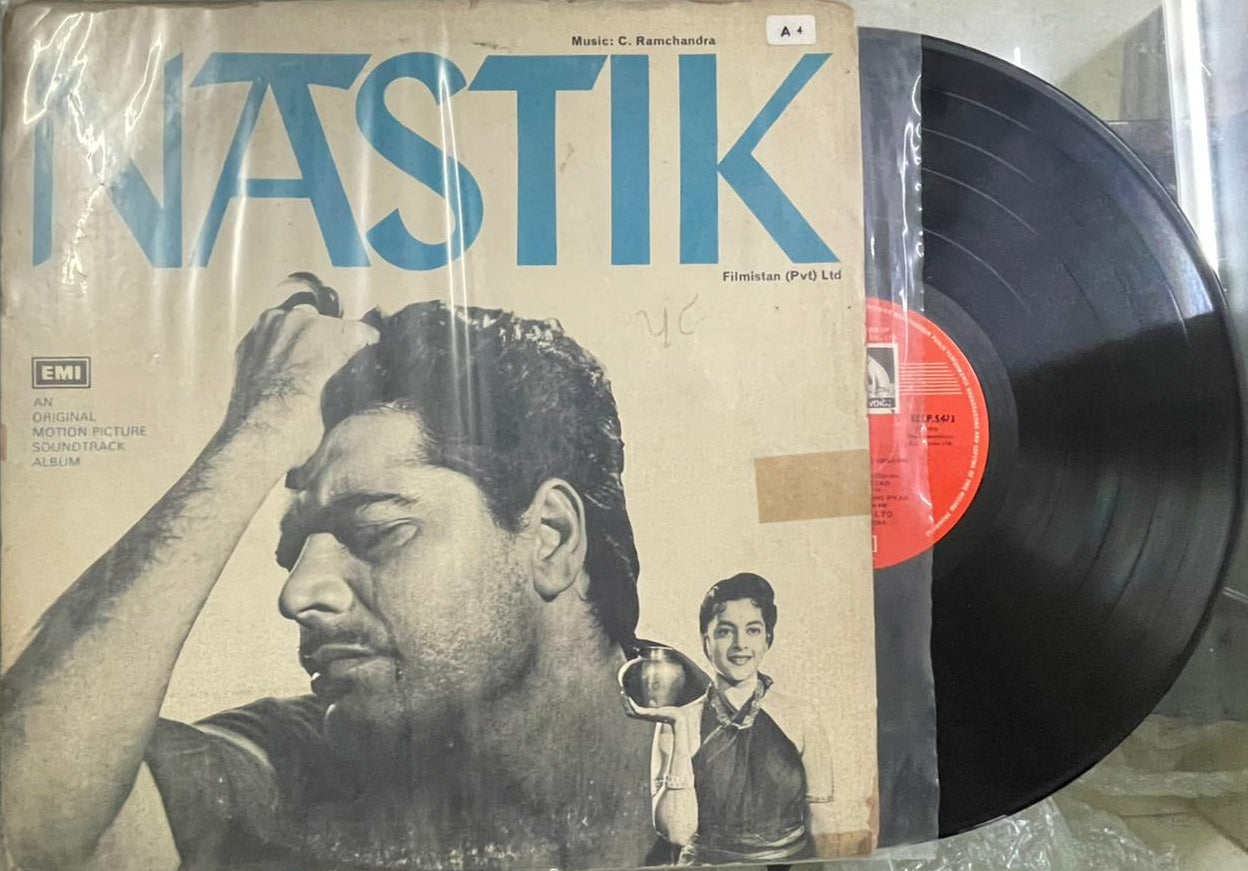 Vinyl record with a cover featuring a person and text, on a reflective surface.