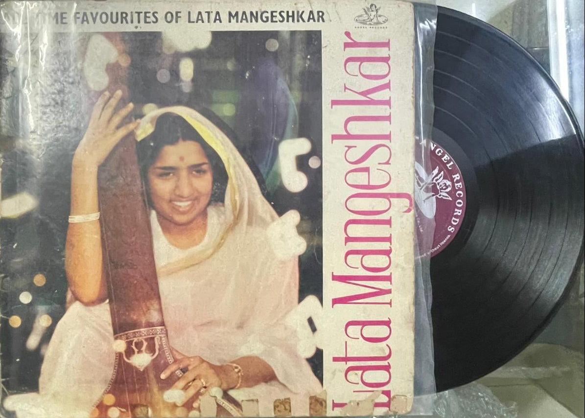 Vinyl record with cover featuring Lata Mangeshkar, showing a person in a white outfit.