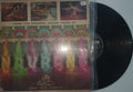 Vinyl record with colorful cover featuring dancing figures on a white background