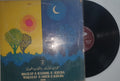 Vinyl record with a colorful cover featuring abstract designs and text.