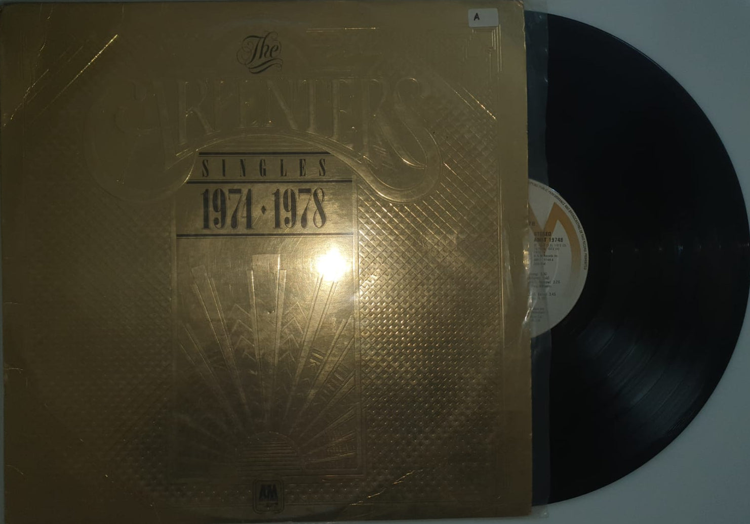 Vinyl record with a gold textured cover on a white background