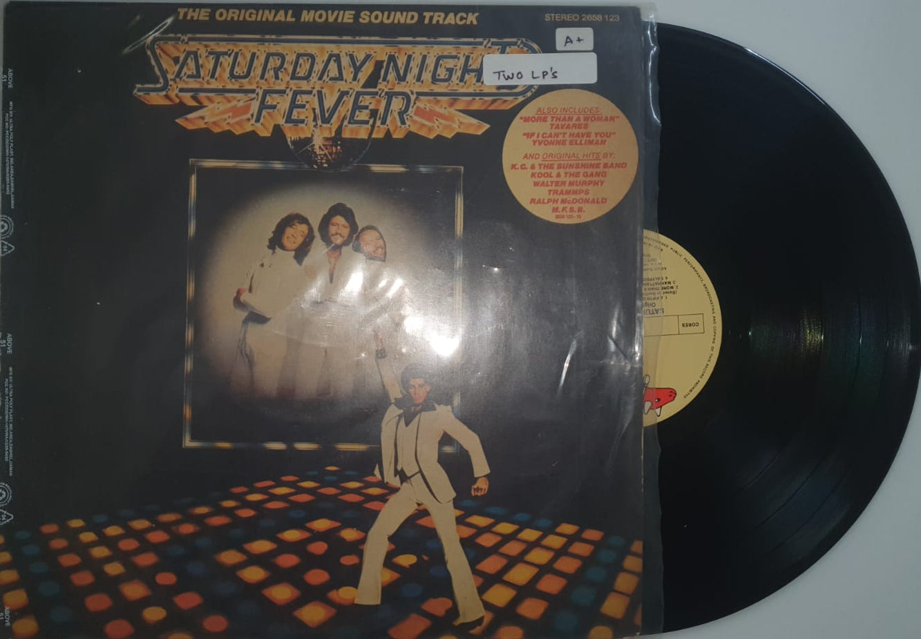 Vinyl record with its cover featuring a geometric design and text on a white background