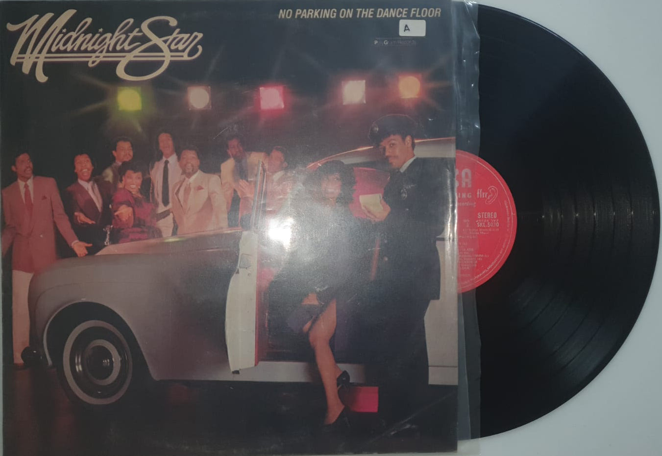 Vinyl record with its cover featuring a band on stage.