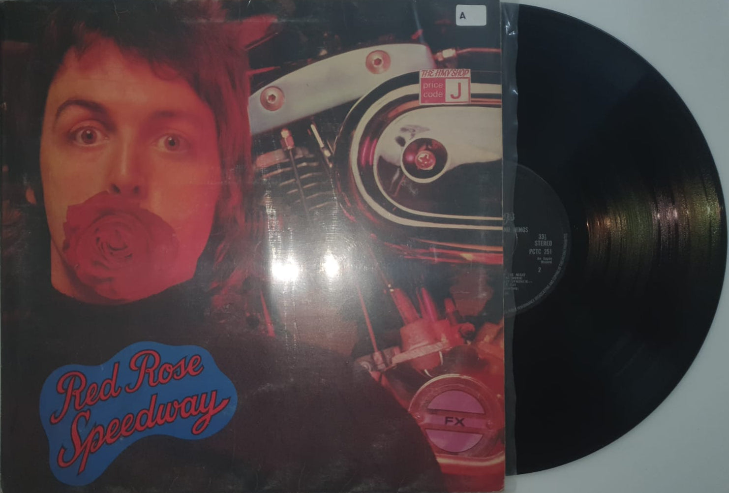 Vinyl record with a colorful cover featuring a person's face and mechanical elements on a white background.