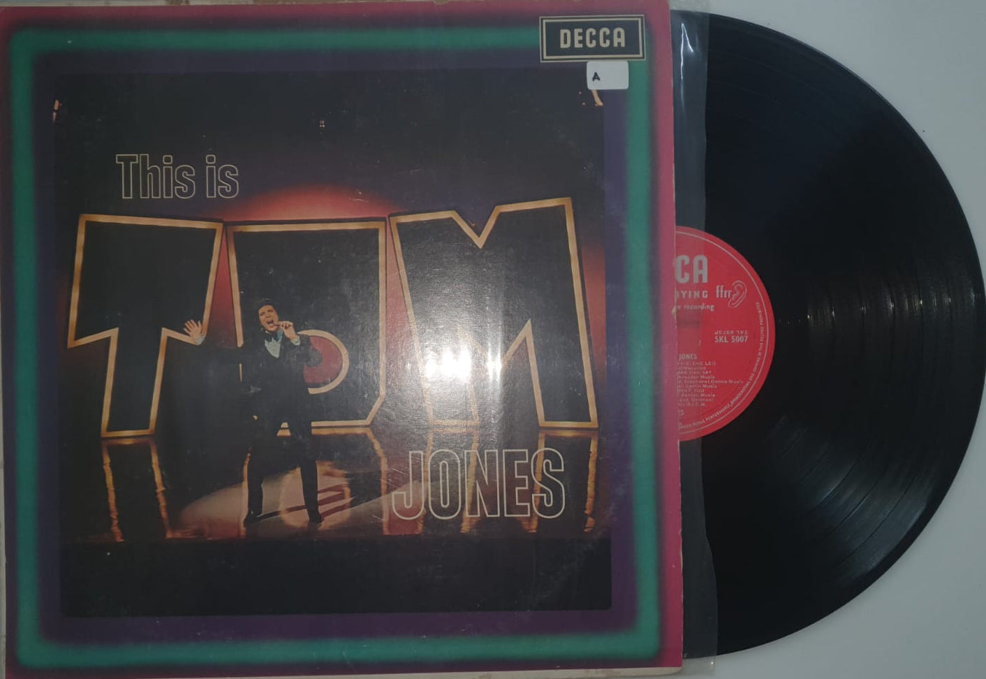 Vinyl record with a colorful cover featuring text and graphics on a white background