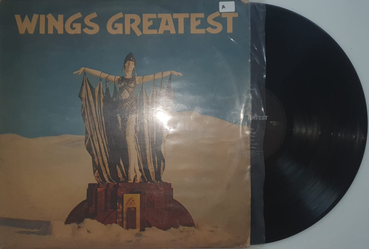 Vinyl record with a cover featuring a statue and 'Wings Greatest' text on a white background