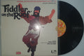 Vinyl record with a cover featuring a stylized illustration of a person holding a fiddle on a plain background.