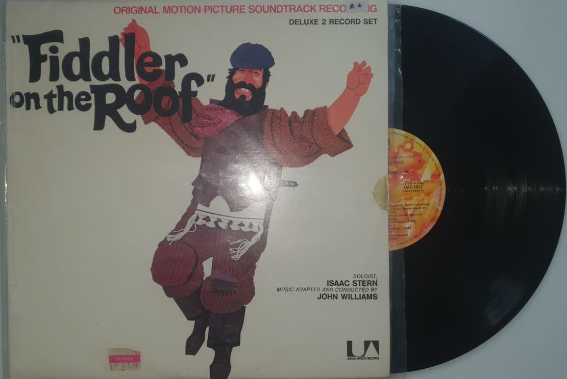 Vinyl record with a cover featuring a stylized illustration of a person holding a fiddle on a plain background.
