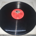 Vinyl record with a red label on a white background